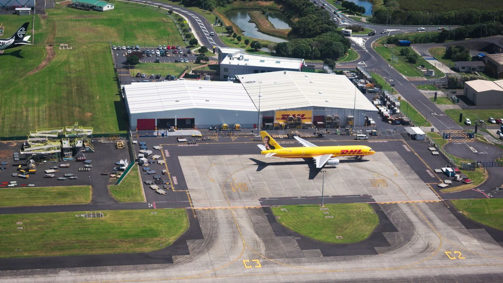 Вид с воздуха на самолет DHL и ангары в оживленном аэропорту